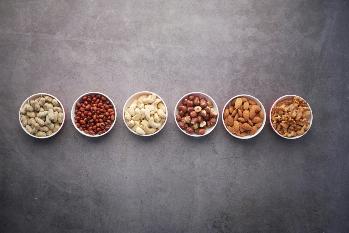 Different high protein nuts in small white bowls. 