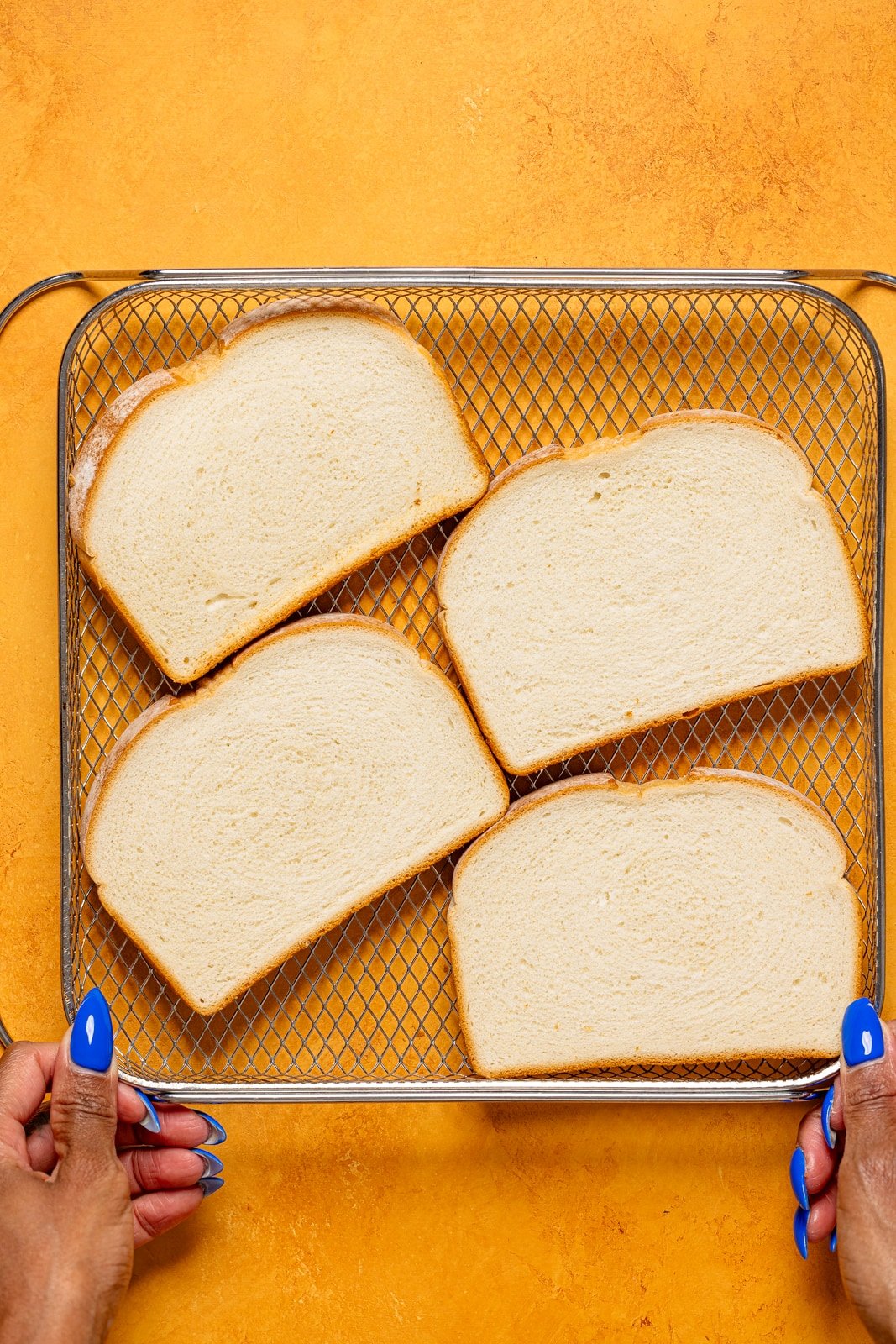 Slices of bread in an Air Fryer basket.