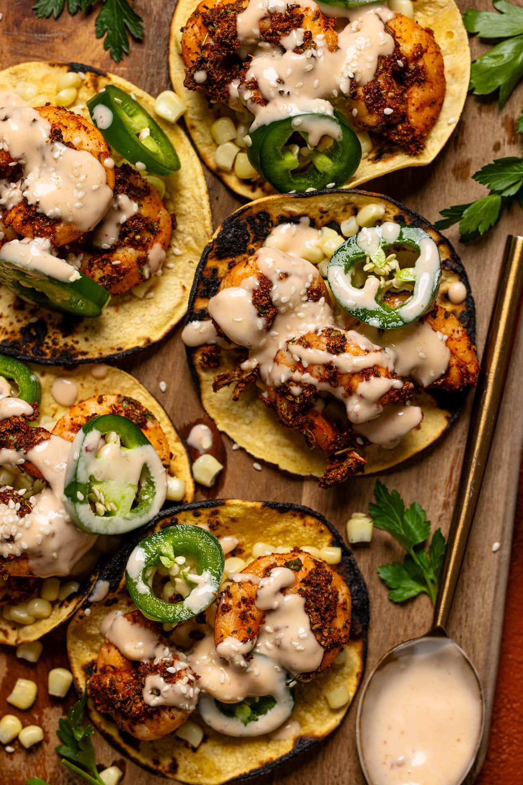 Shrimp tacos on a cutting board with a spoon.