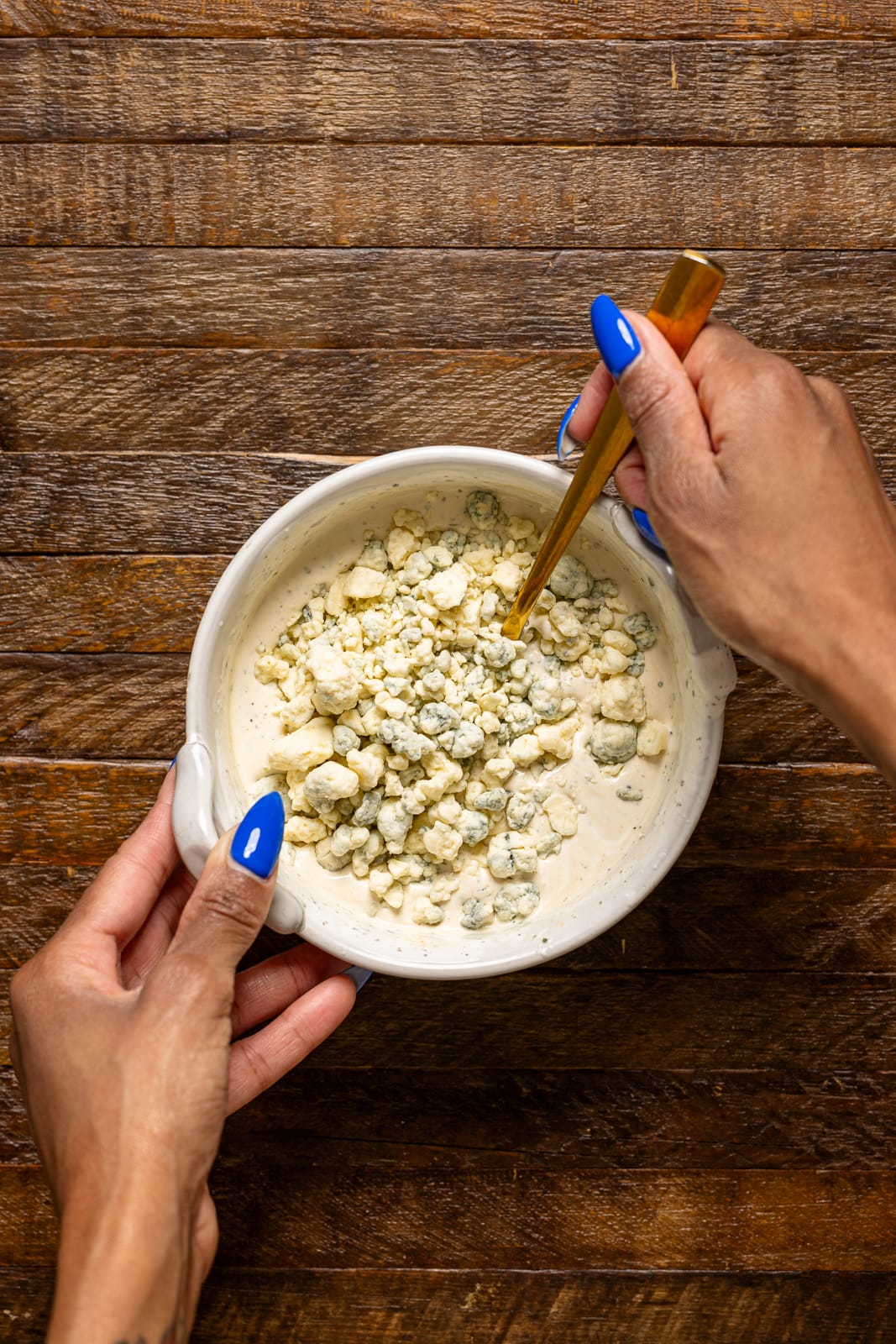 Dressing ingredients in a bowl being stirred.