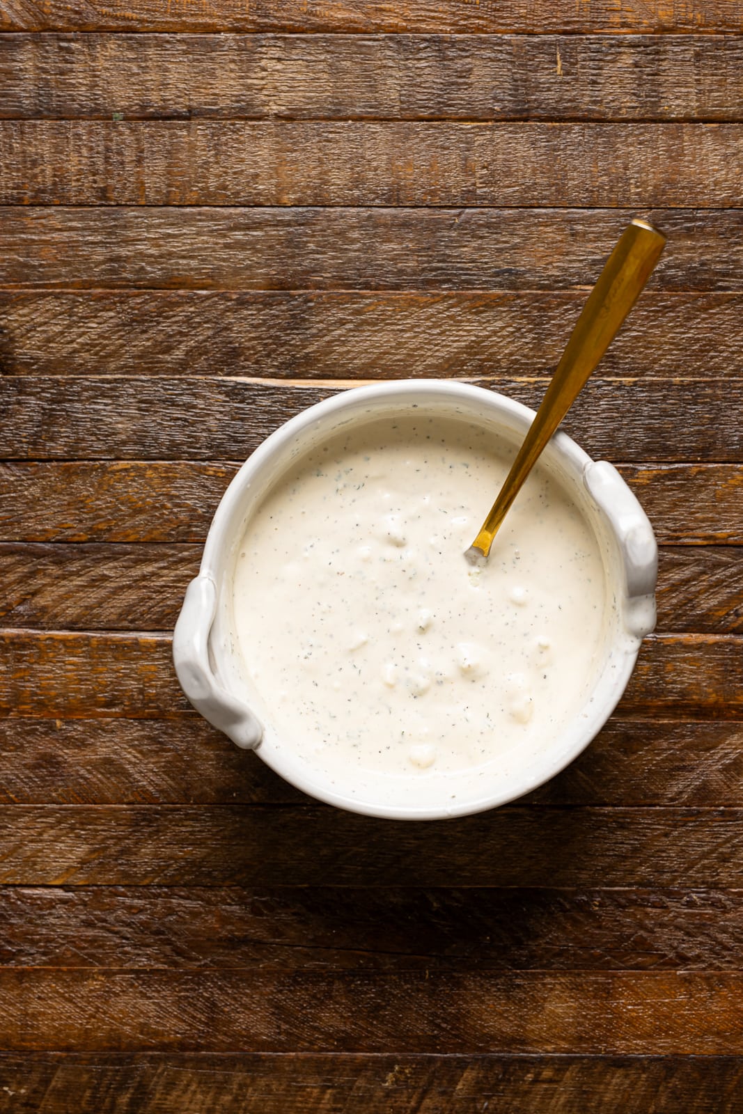 Dressing in a white bowl with a spoon.