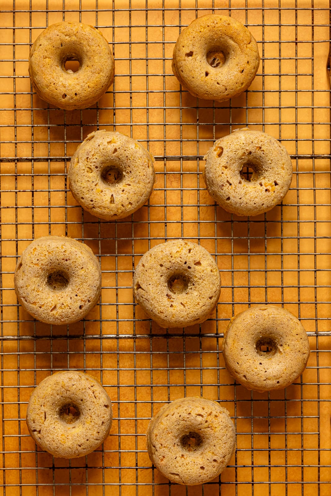 Baked donuts on a wire rack.