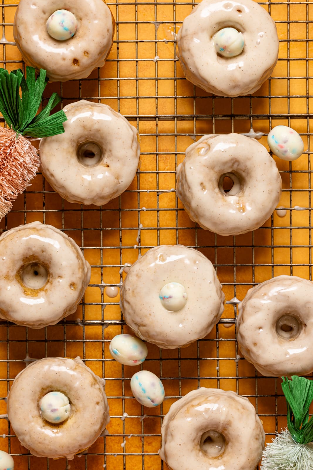 Donuts on a wire rack with Easter decor.