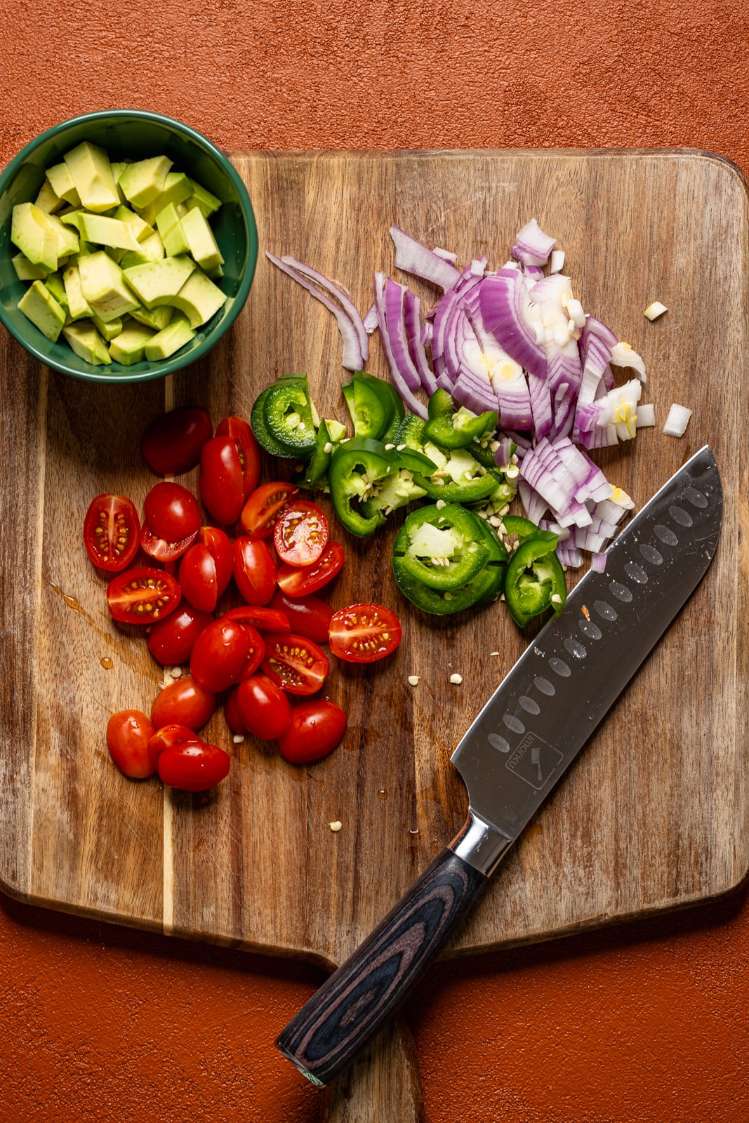 Ingredients chopped on a cutting board with a knife.