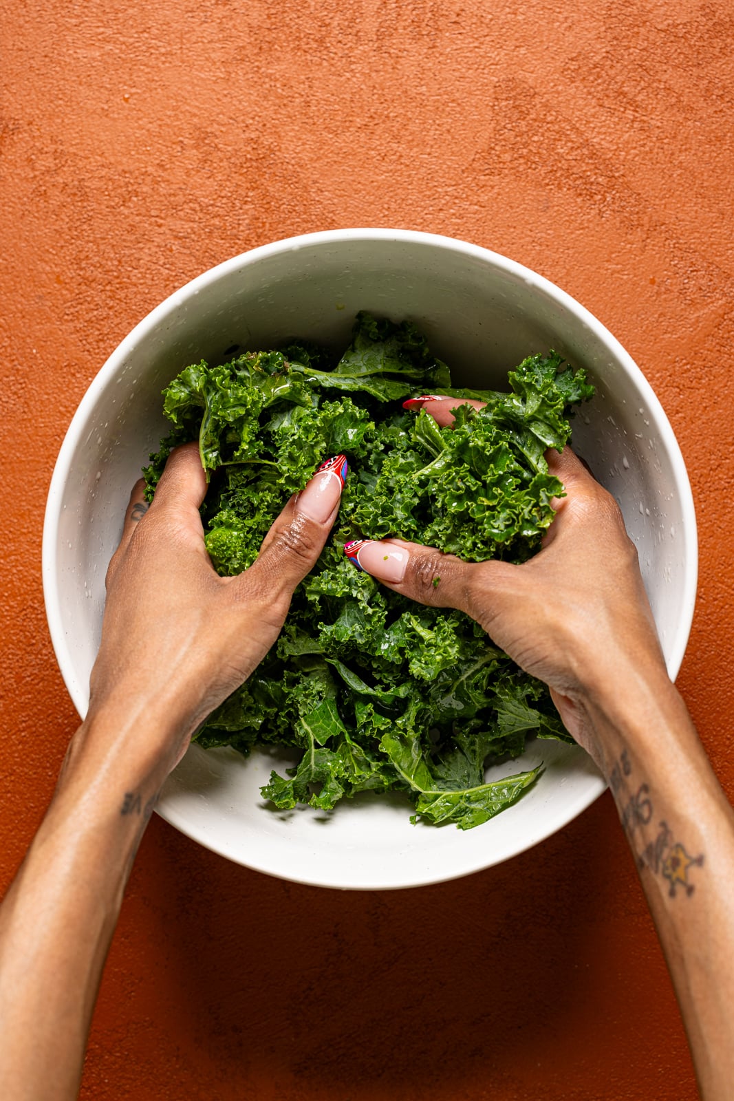 Chopped kale being massaged in a bowl.
