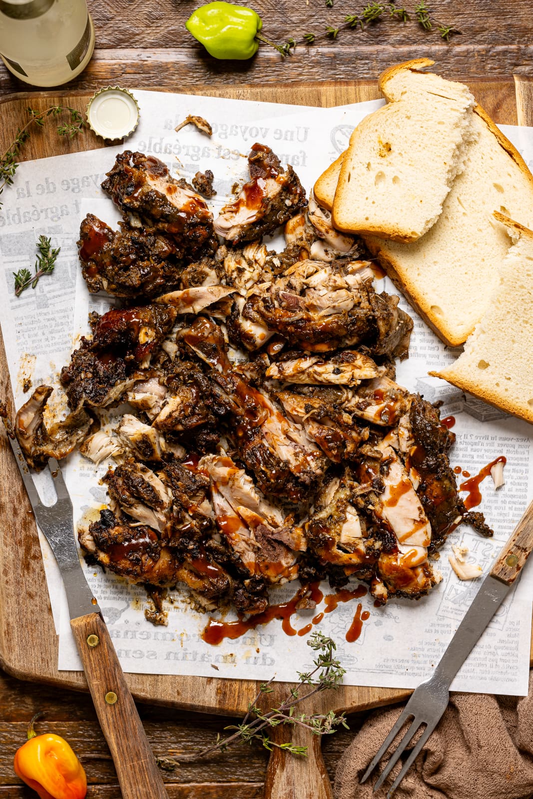 Chopped jerk chicken on a cutting board with bread and a fork. A delicious man pleasing dinner + meal.