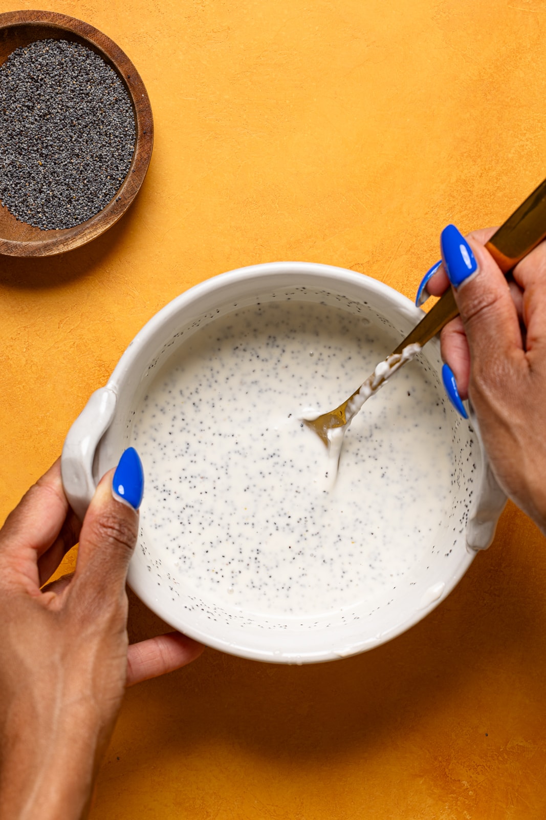 Dressing in a bowl being stirred with a spoon.