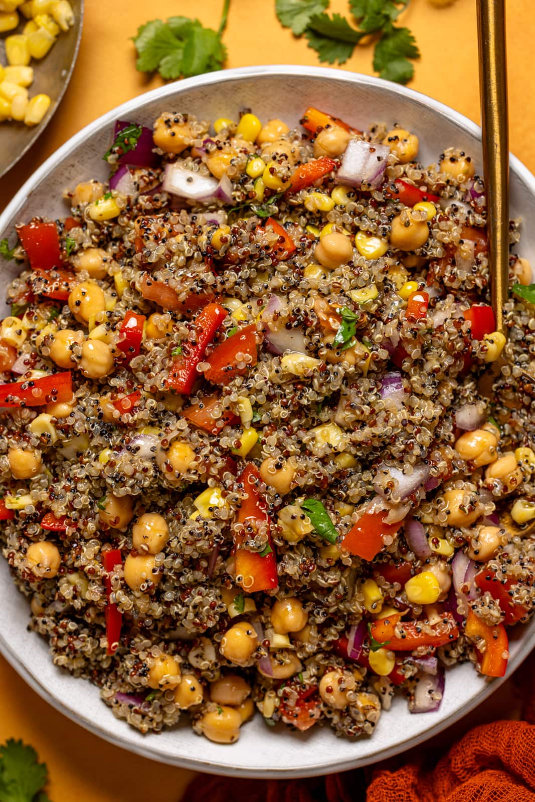 Up close shot of quinoa salad in a bowl with a spoon.