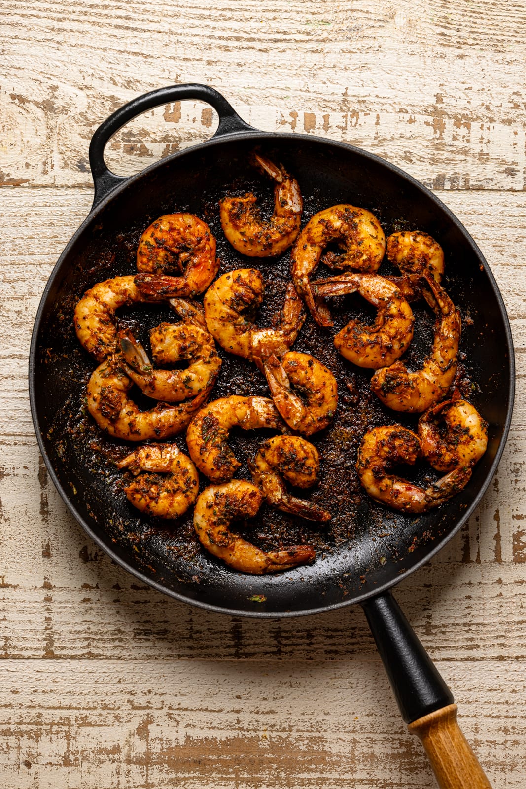 Sautéed shrimp in a black skillet.