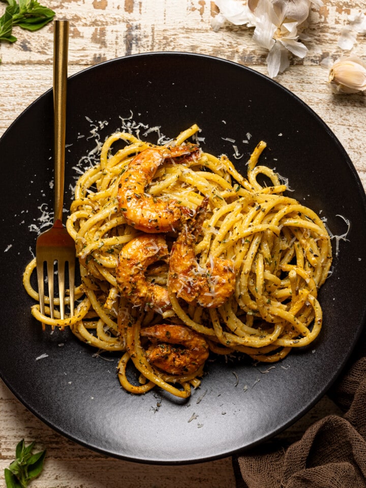 Shrimp pasta on a black plate with a fork.