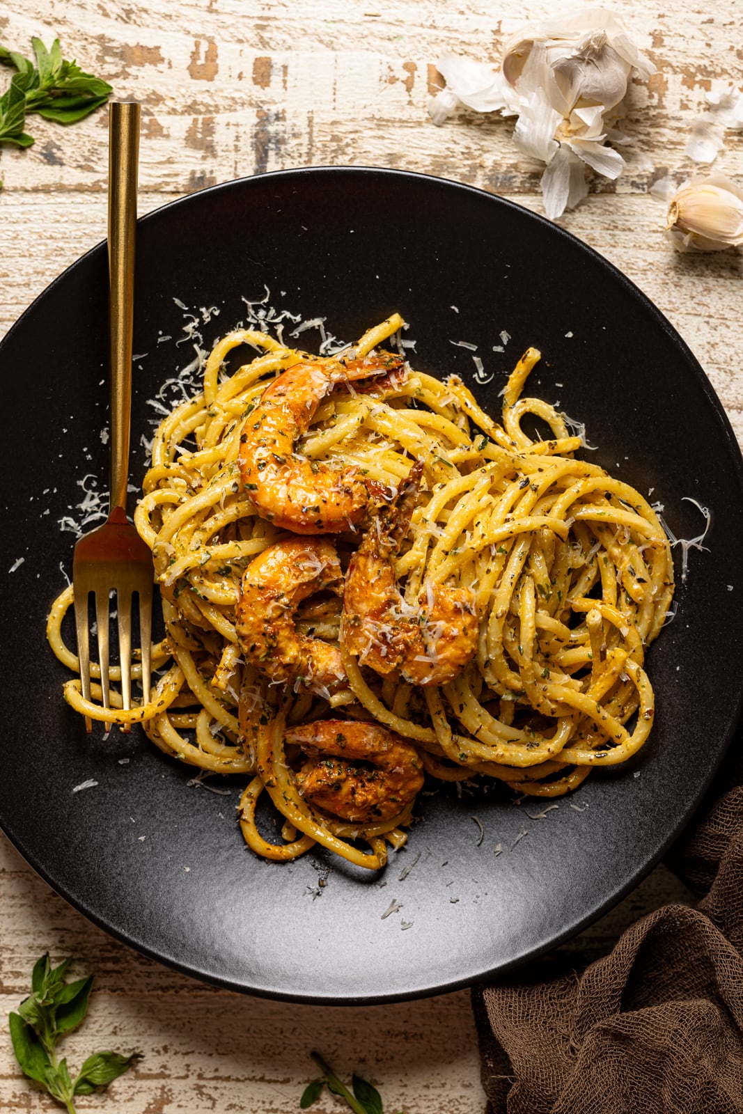 Shrimp pasta on a black plate with a fork.