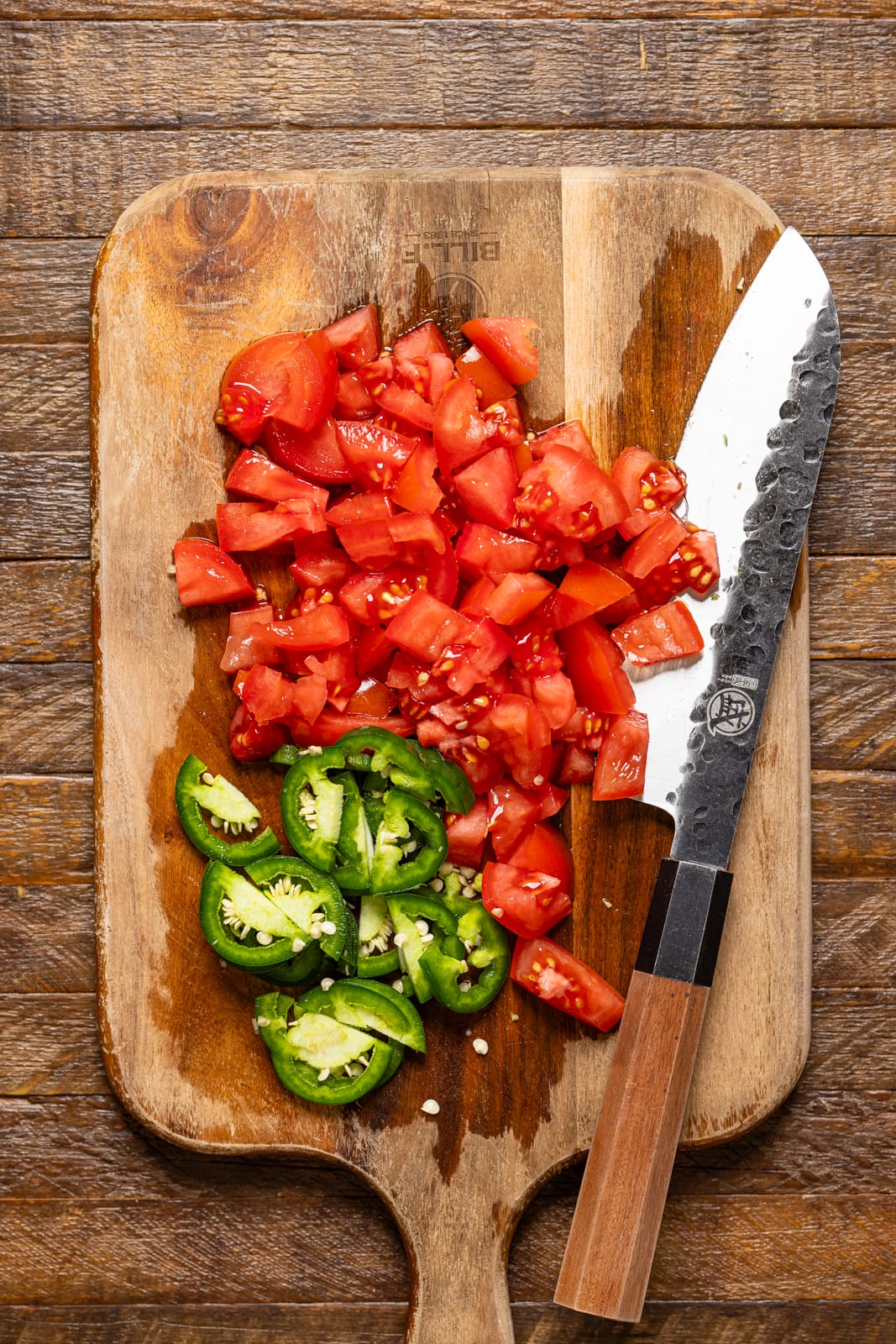 Chopped veggies on a cutting board with a knife.