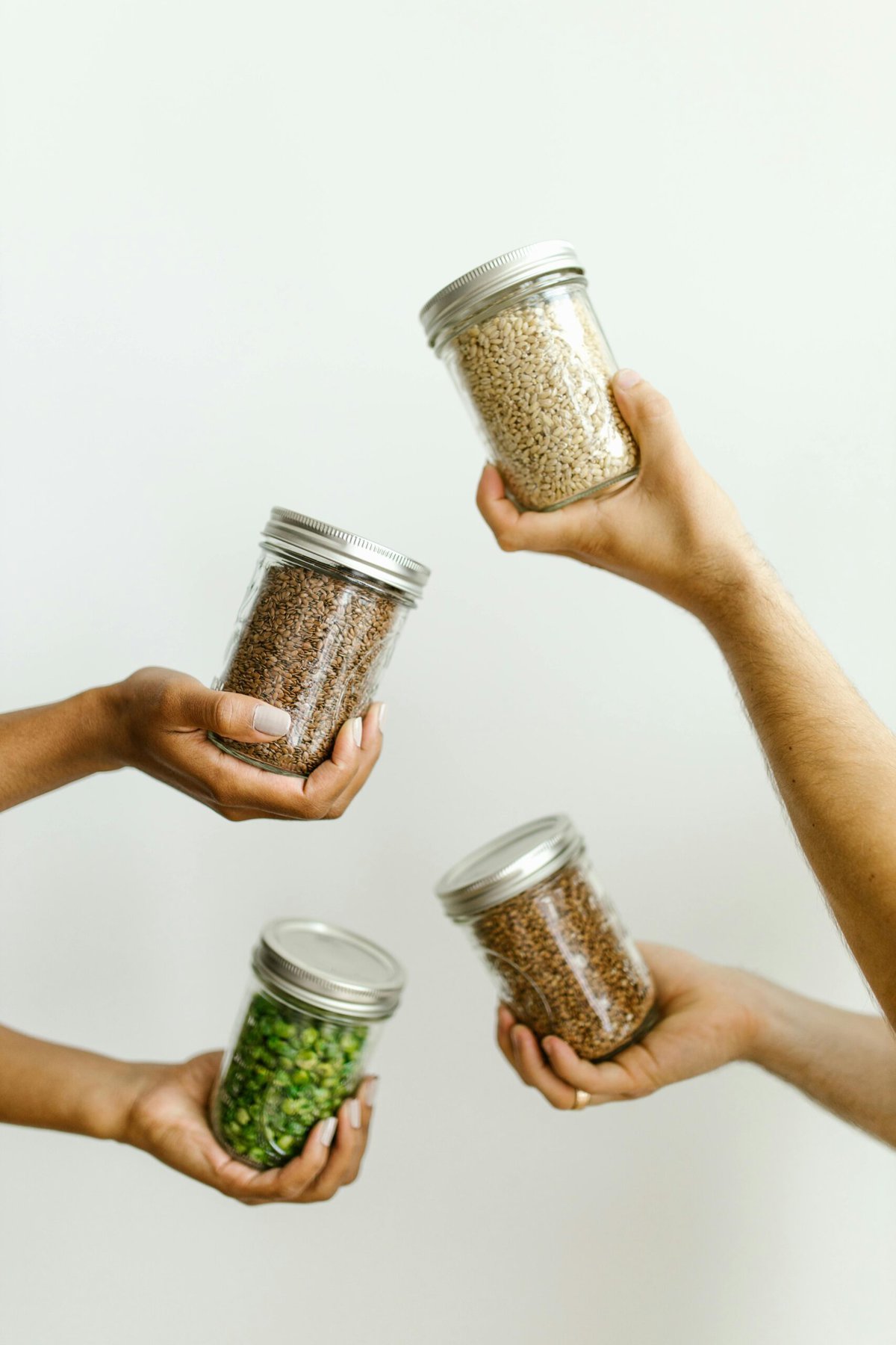 Hands holding jars on dry ingredients.