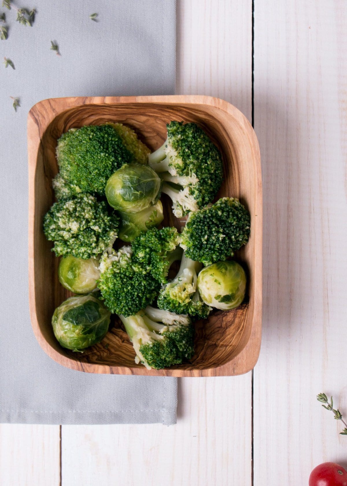 Broccoli and brussels sprouts in a wooden bowl.
