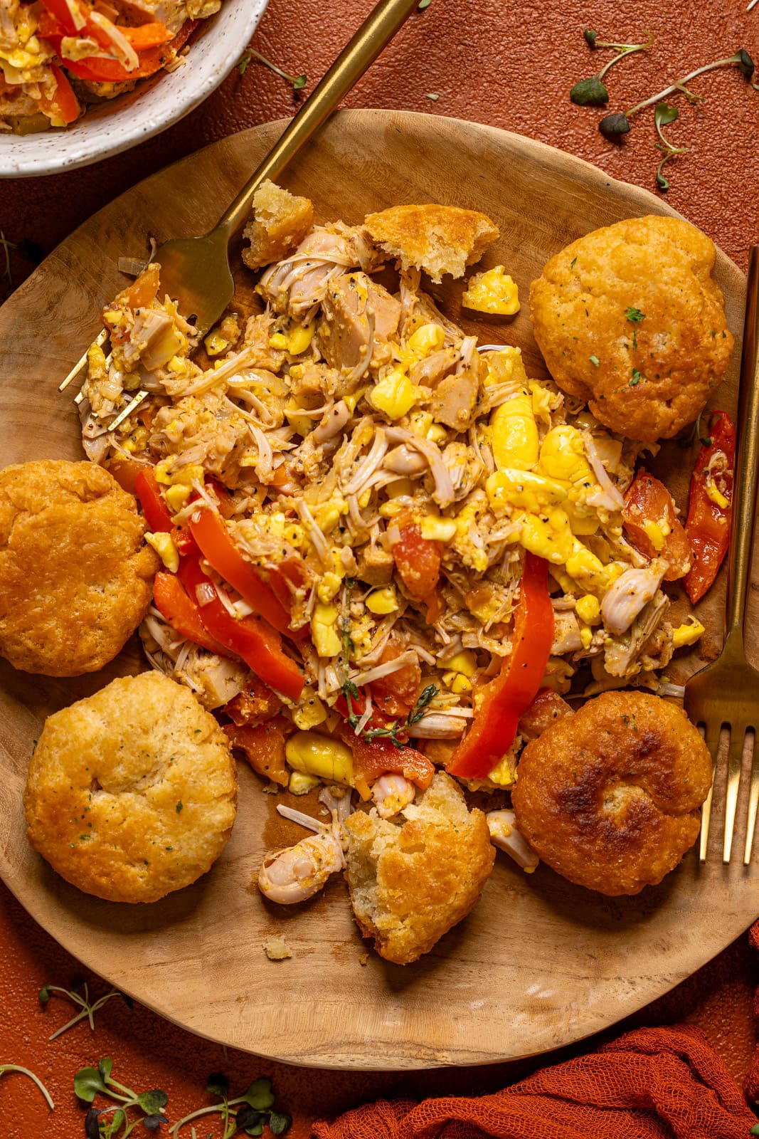 Ackee and saltfish with fried dumplings on a wooden plate with a fork.