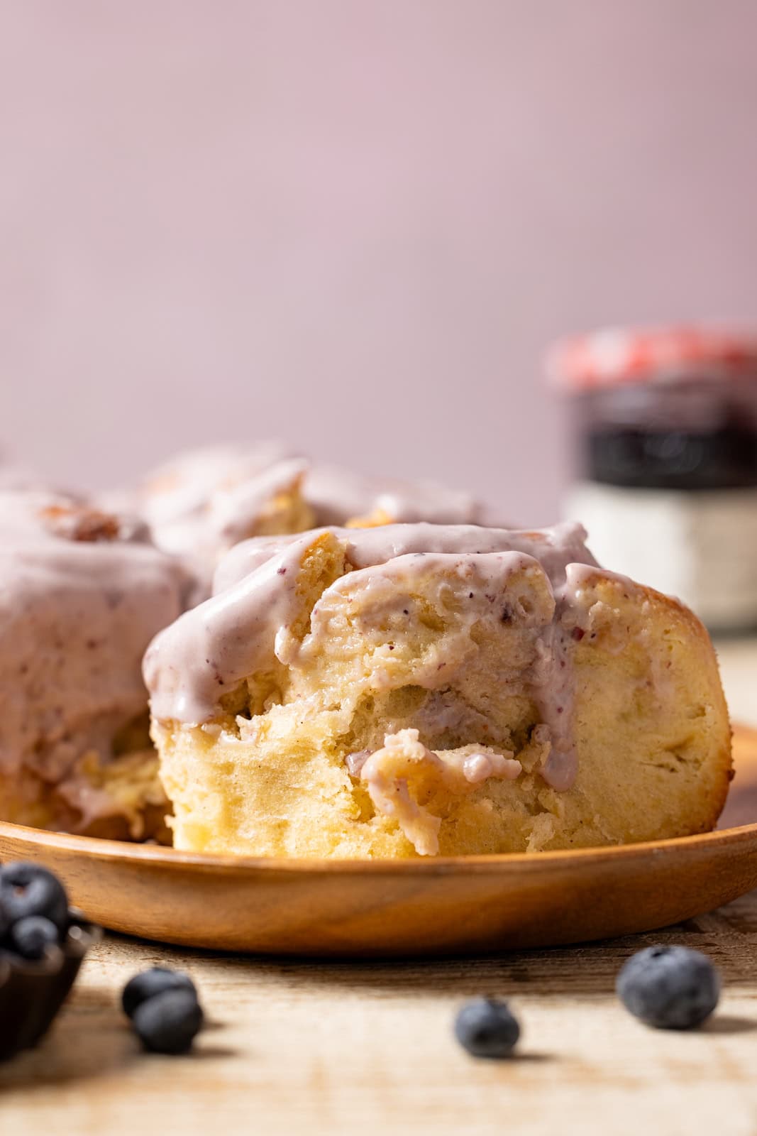 Cinnamon rolls in plates with jam and blueberries.