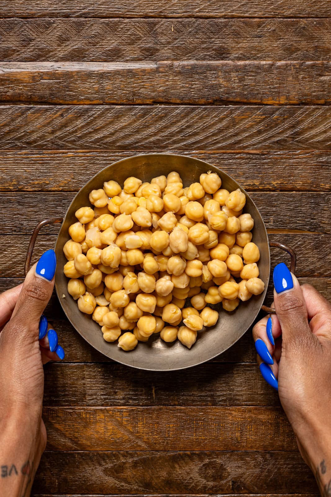 Bowl with drained and rinsed chickpeas being held.