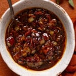 Up close shot of bacon jam in a bowl with a spoon.