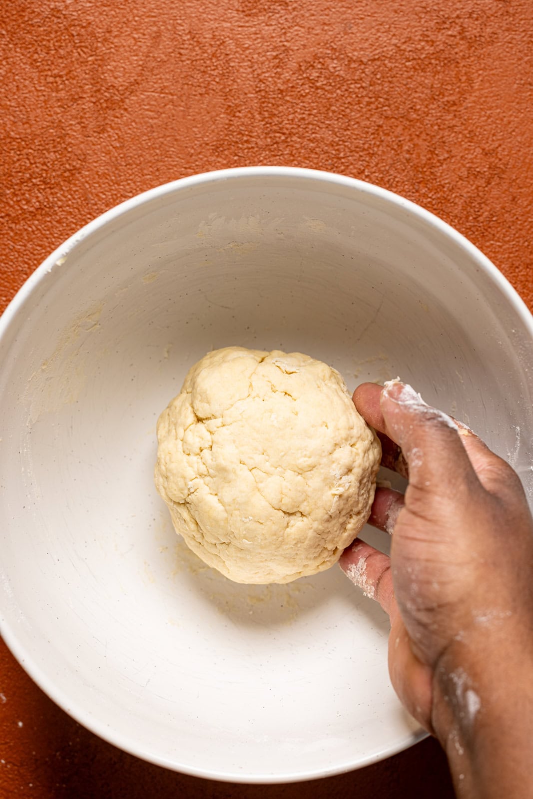 Dough being held in a white bowl.