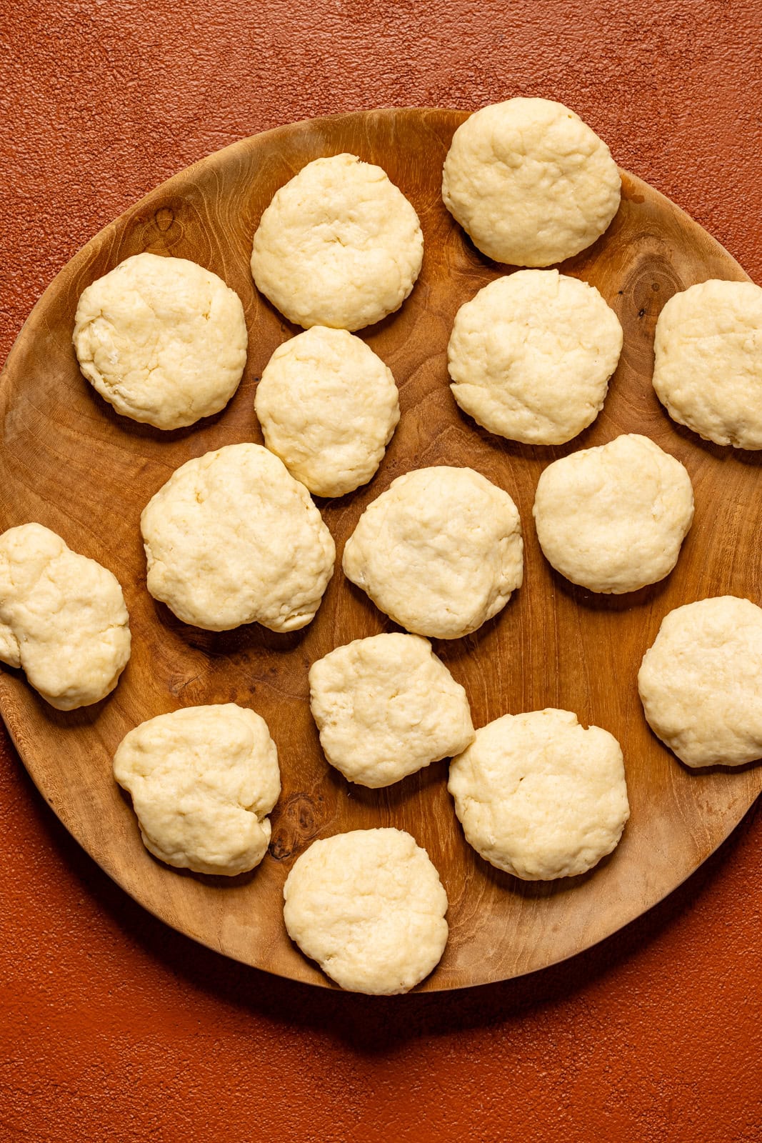 Rolled dumpling dough on a wooden plate. 