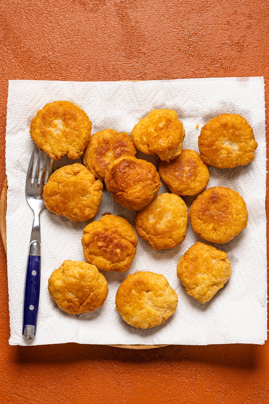 Fried dumpling on a paper towel on a plate with a fork.