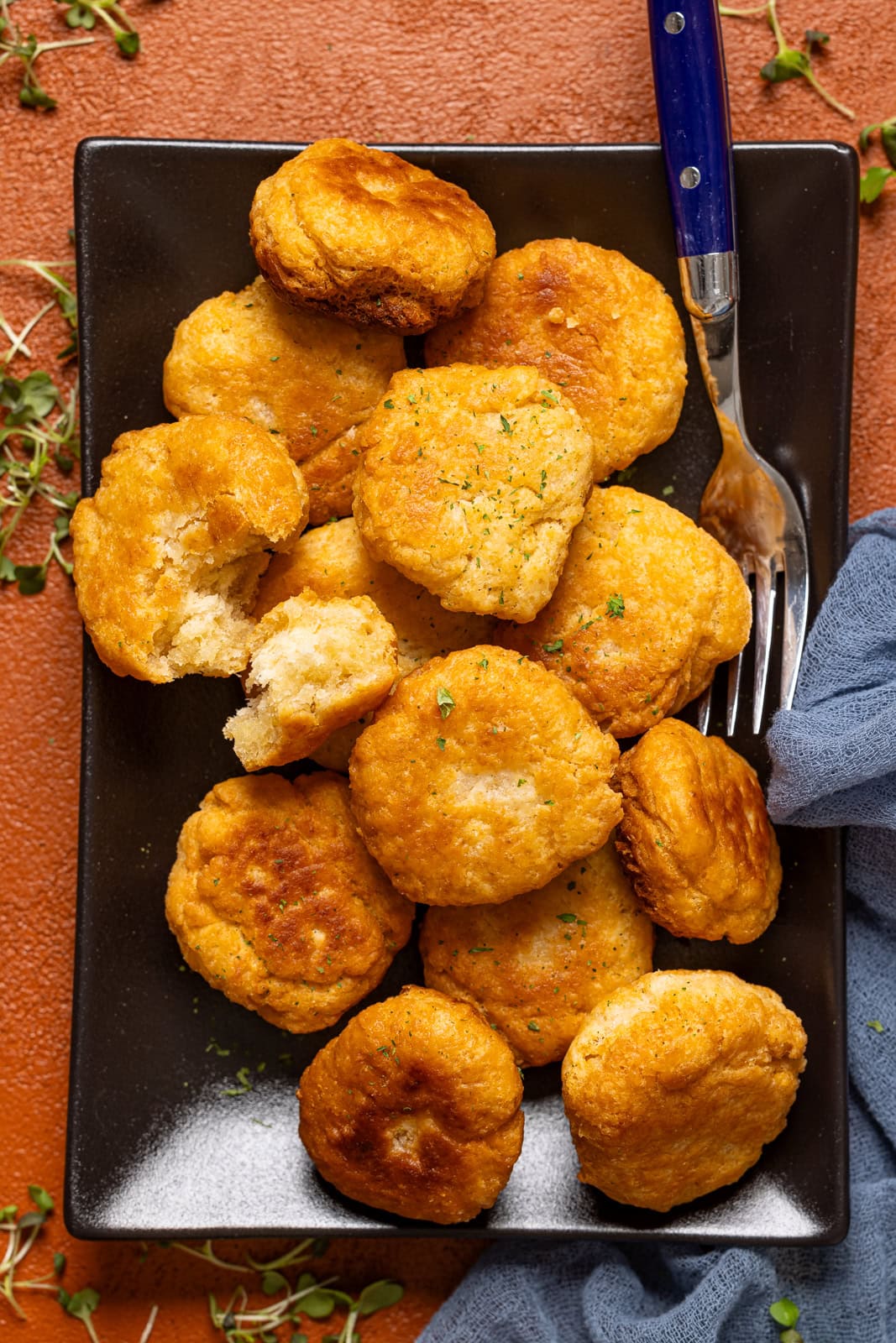 Fried dumpling on a black platter with a fork.