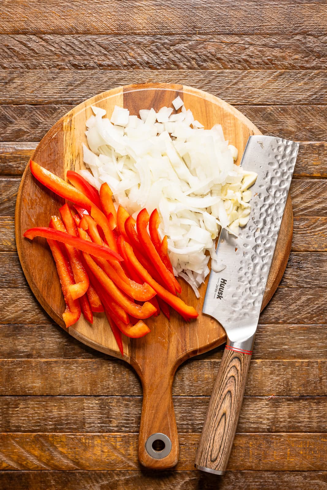 Chopped veggies on a cutting board with a knife.