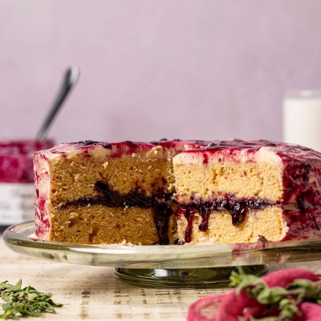 Cake sliced with milk and jam in the background.