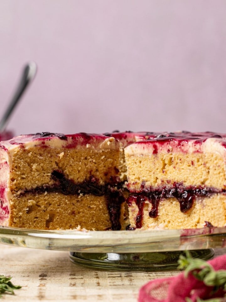 Cake sliced with milk and jam in the background.