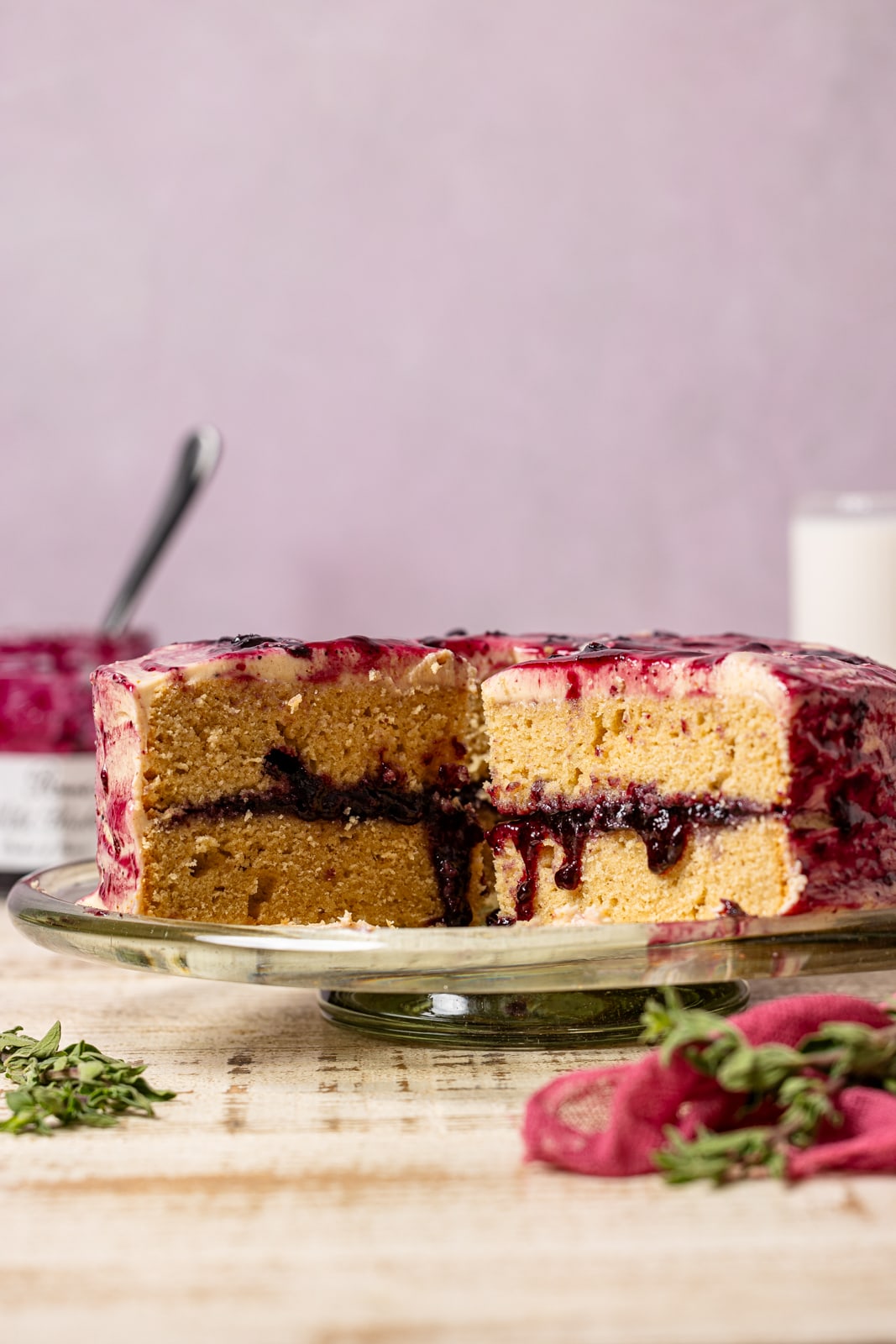 Cake sliced with milk and jam in the background.