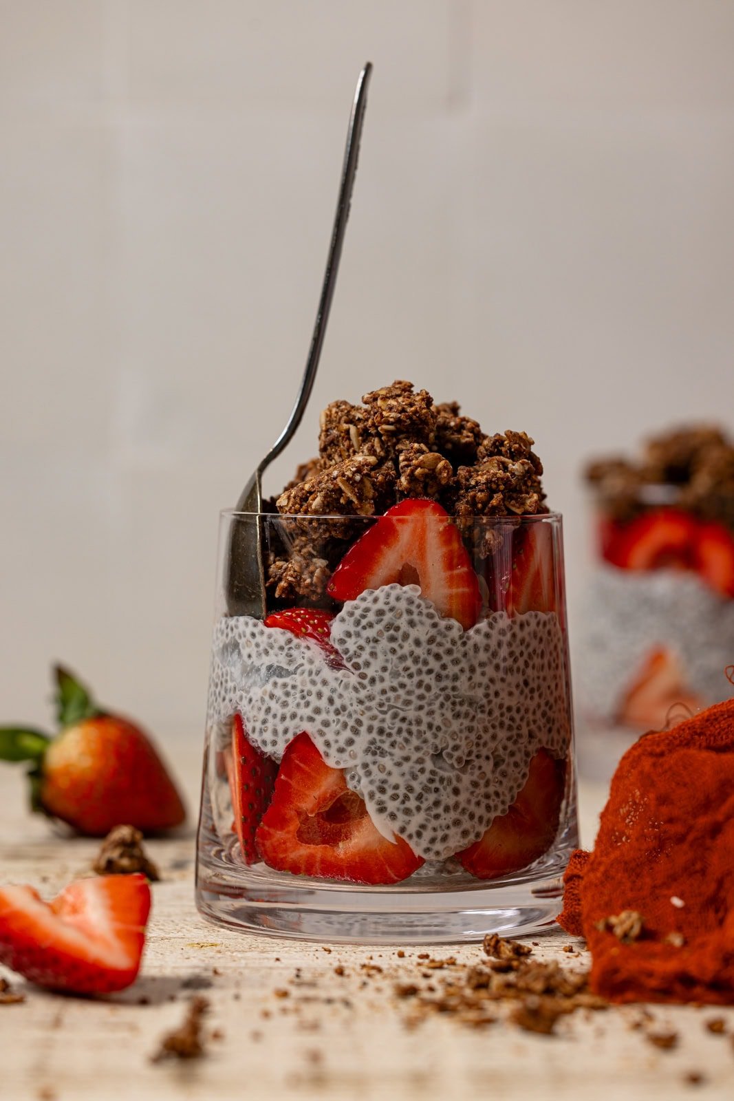 Cup of chia pudding with strawberries and a spoon.