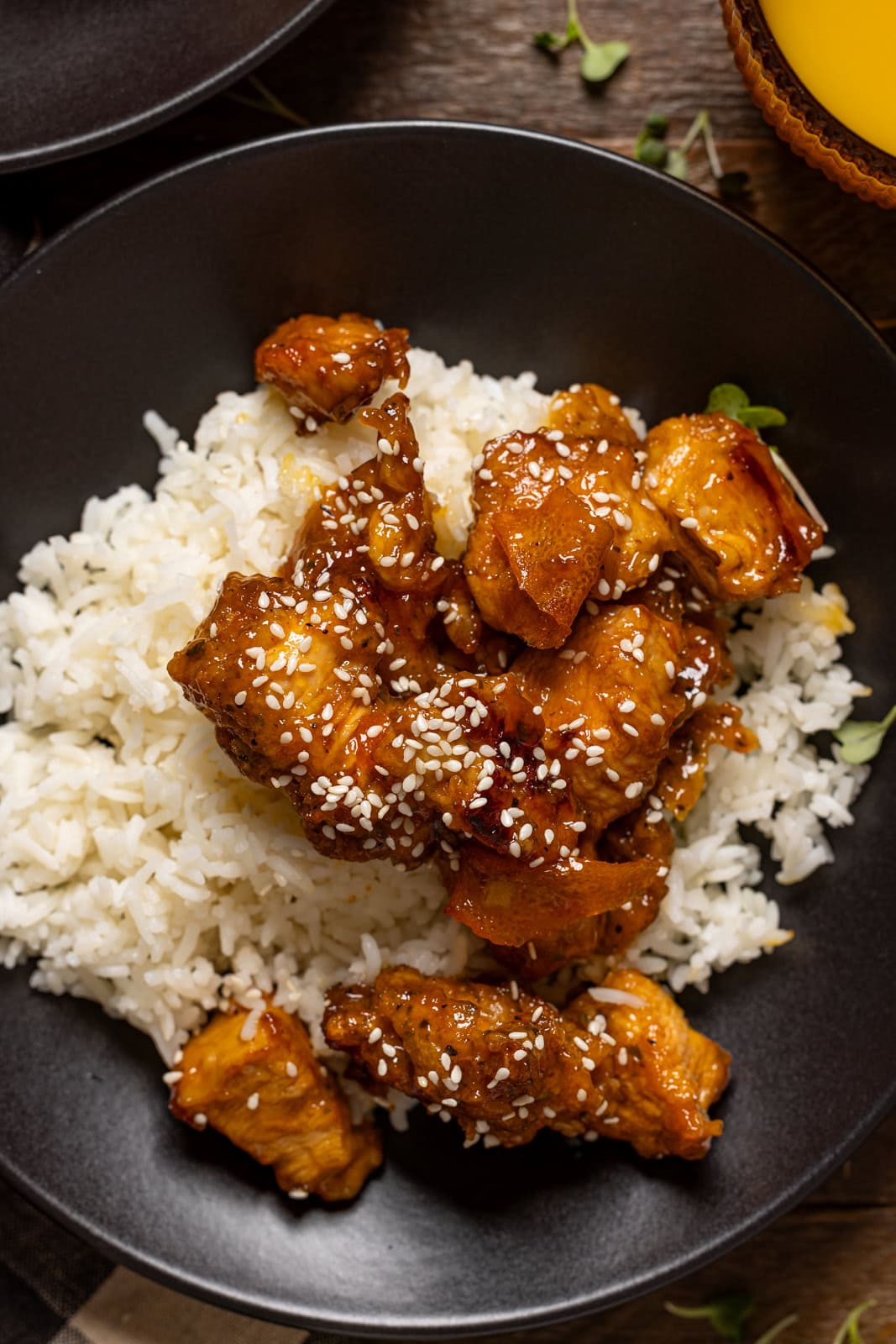 Up close shot of orange chicken in black plate.