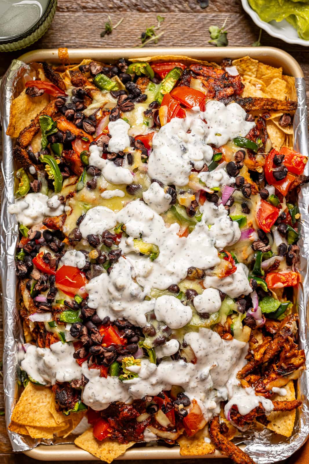 Baked bbq chicken nachos on a baking sheet.