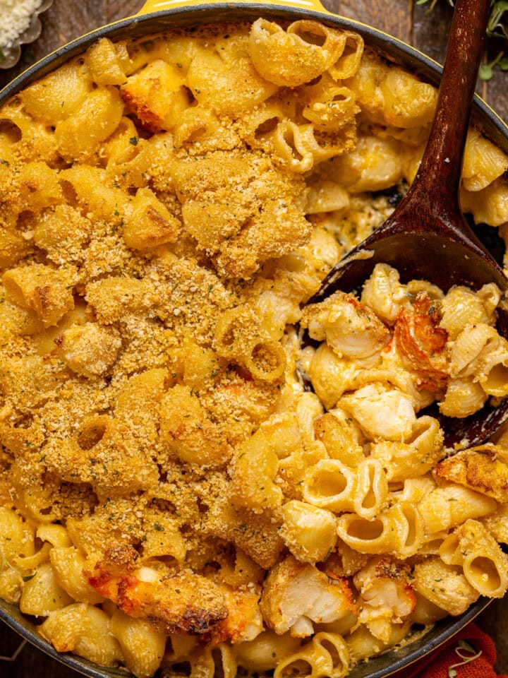 Up close shot of baked mac and cheese with a wooden spoon.