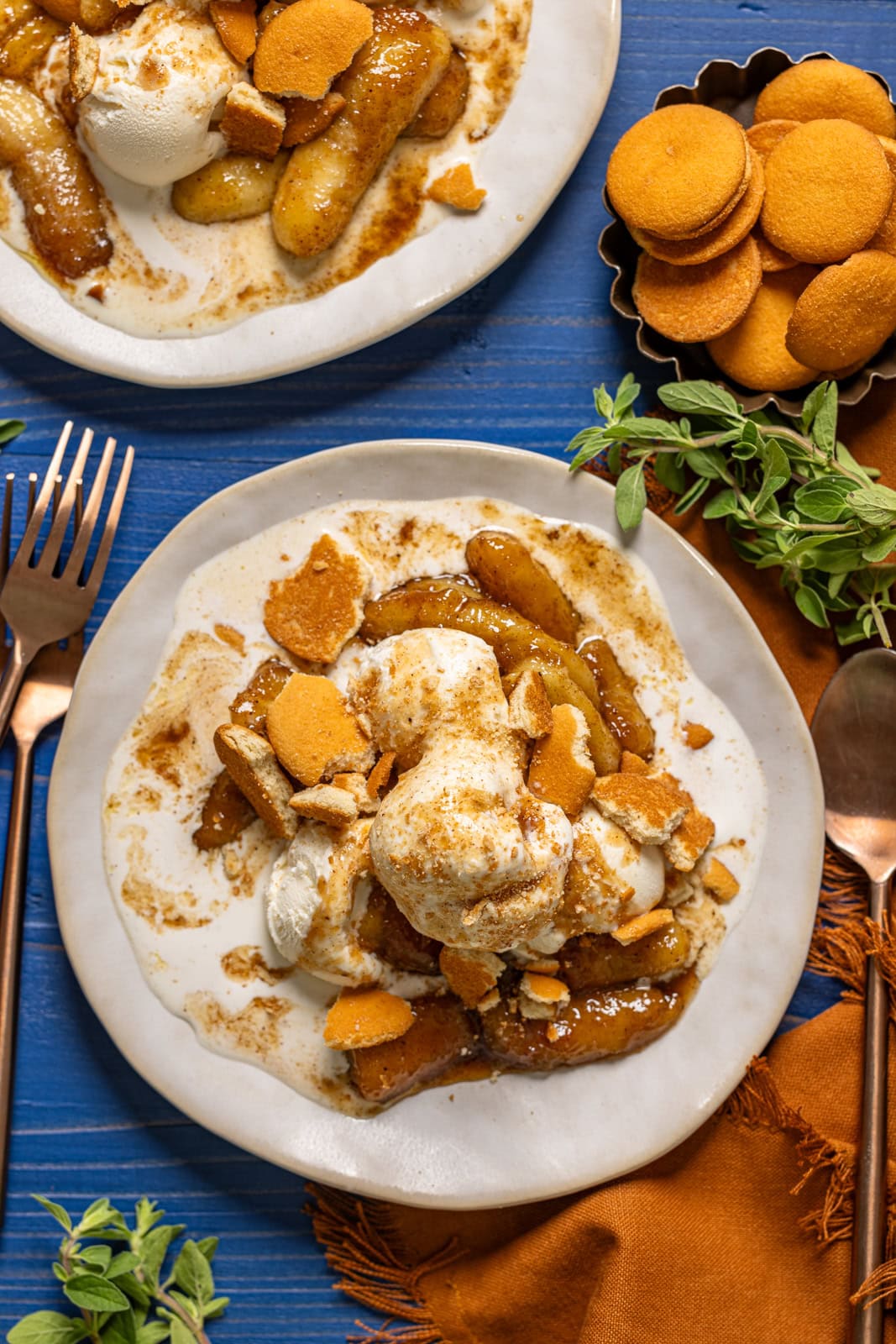Bananas foster in two plates with a fork and spoon.