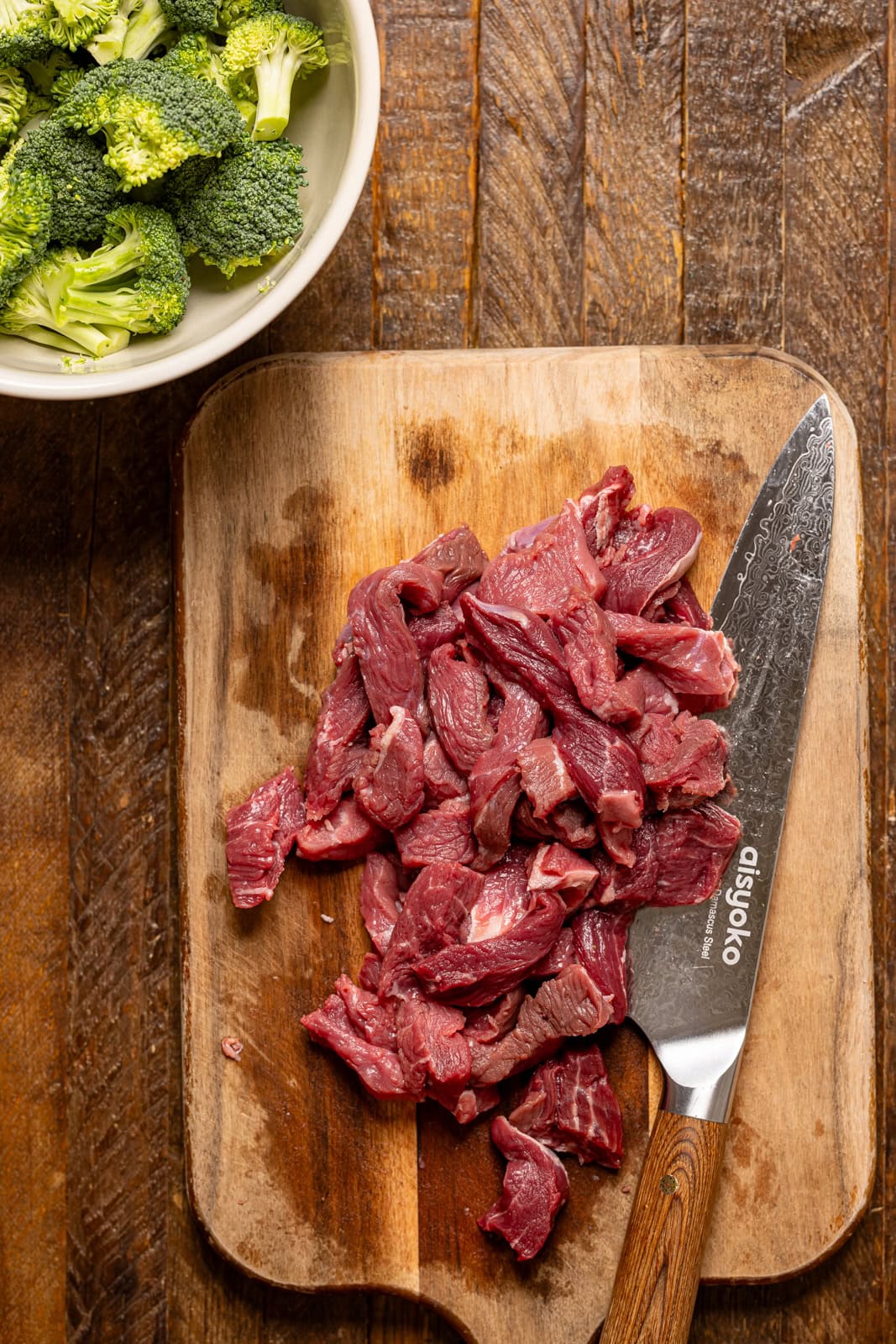 Chopped meat on a cutting board with a knife.