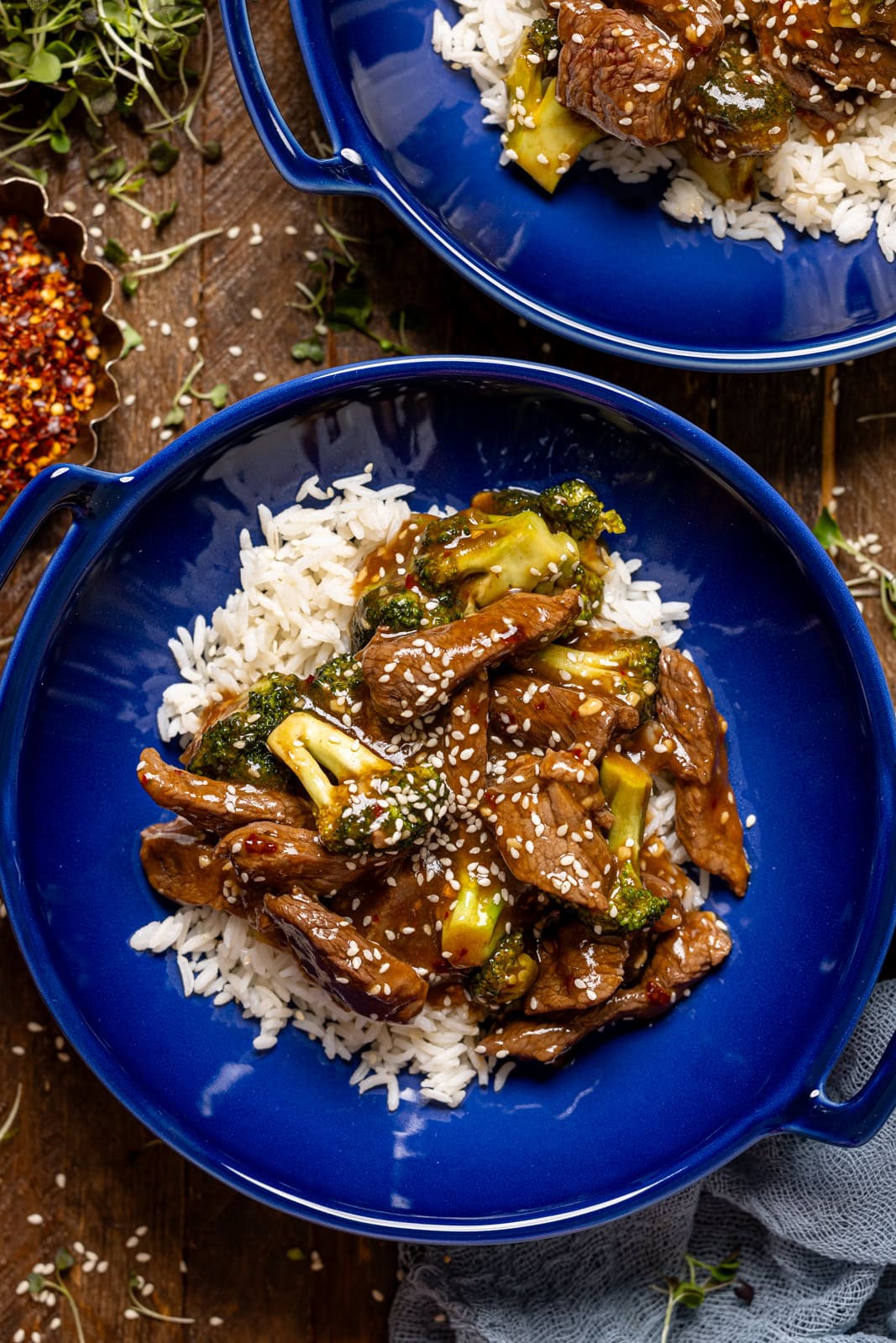 Up close shot of beef and broccoli in a blue plate. A delcious man pleasing dinner + meal