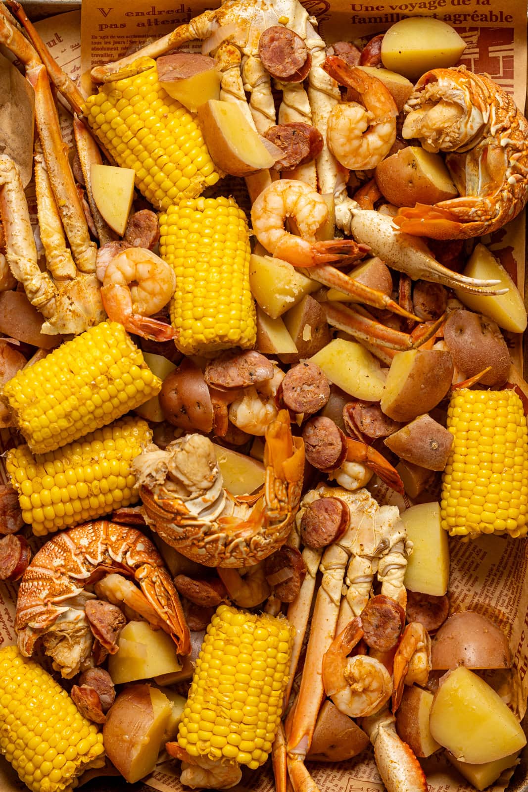 All cooked seafood and veggies on a large baking sheet.