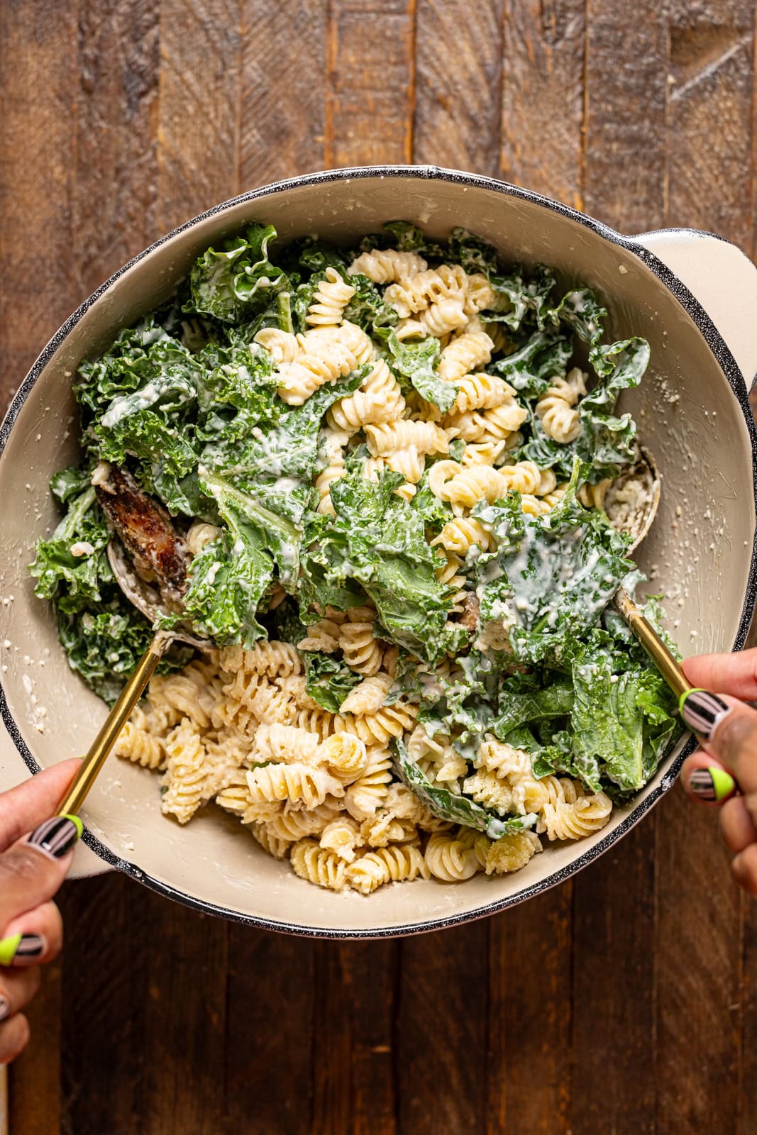 All chicken pasta salad ingredients being mixed together in a bowl.