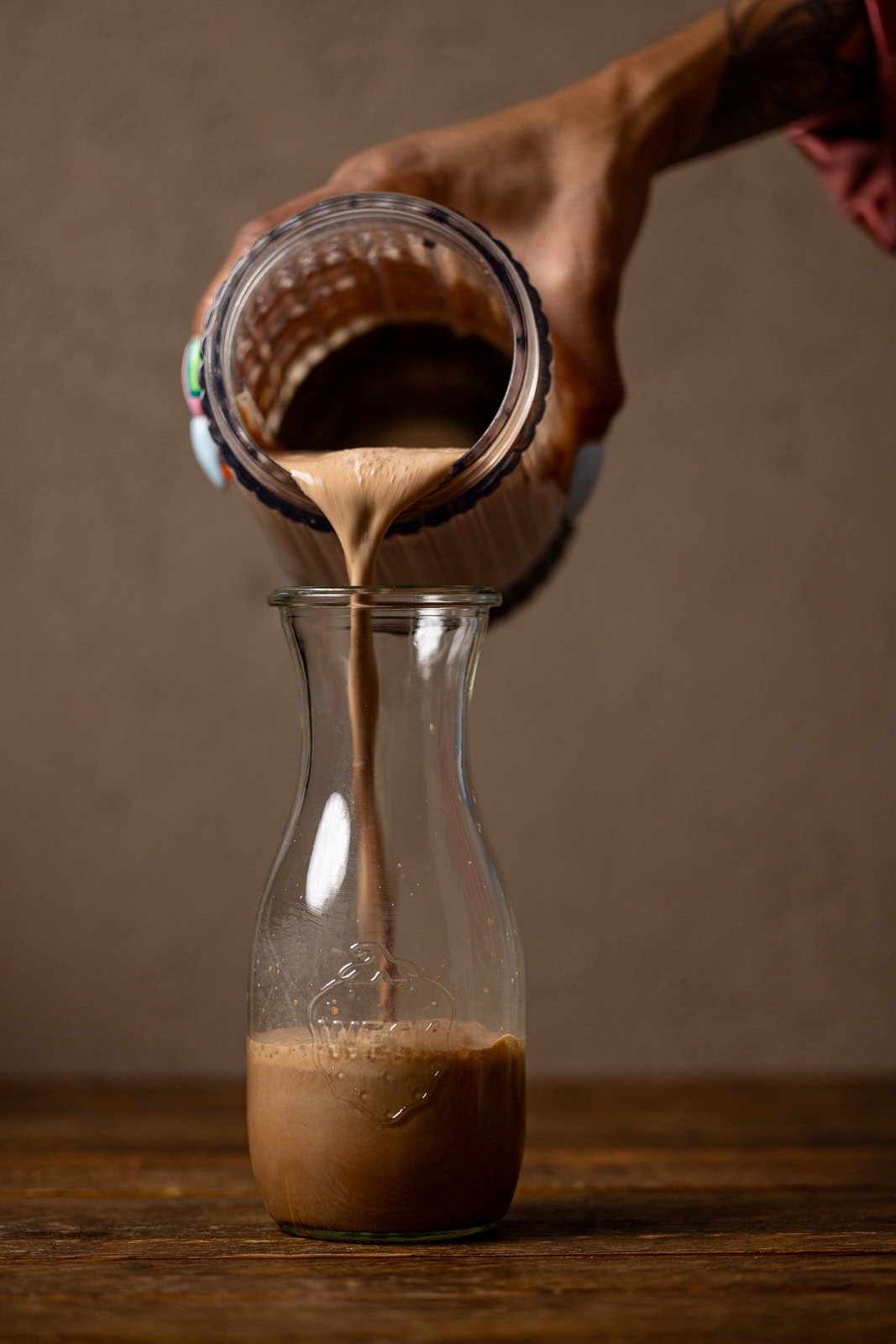 Chocolate milk being poured in a jar. 