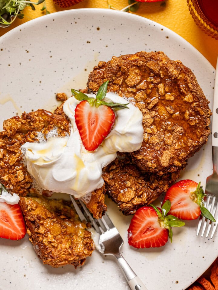 Up close shot of french toast on a plate with two forks.