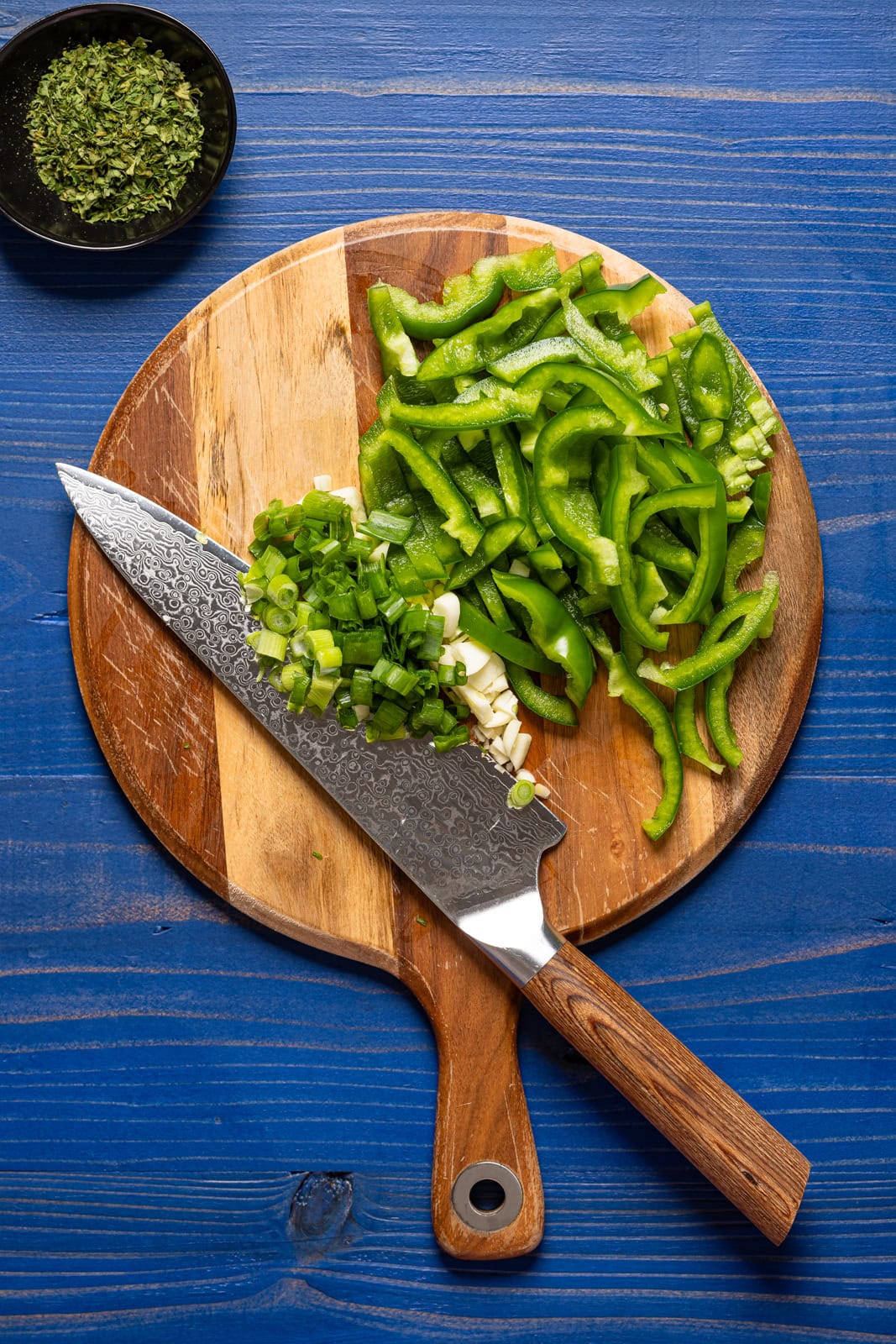 Chopped veggies on a cutting board with a knife.