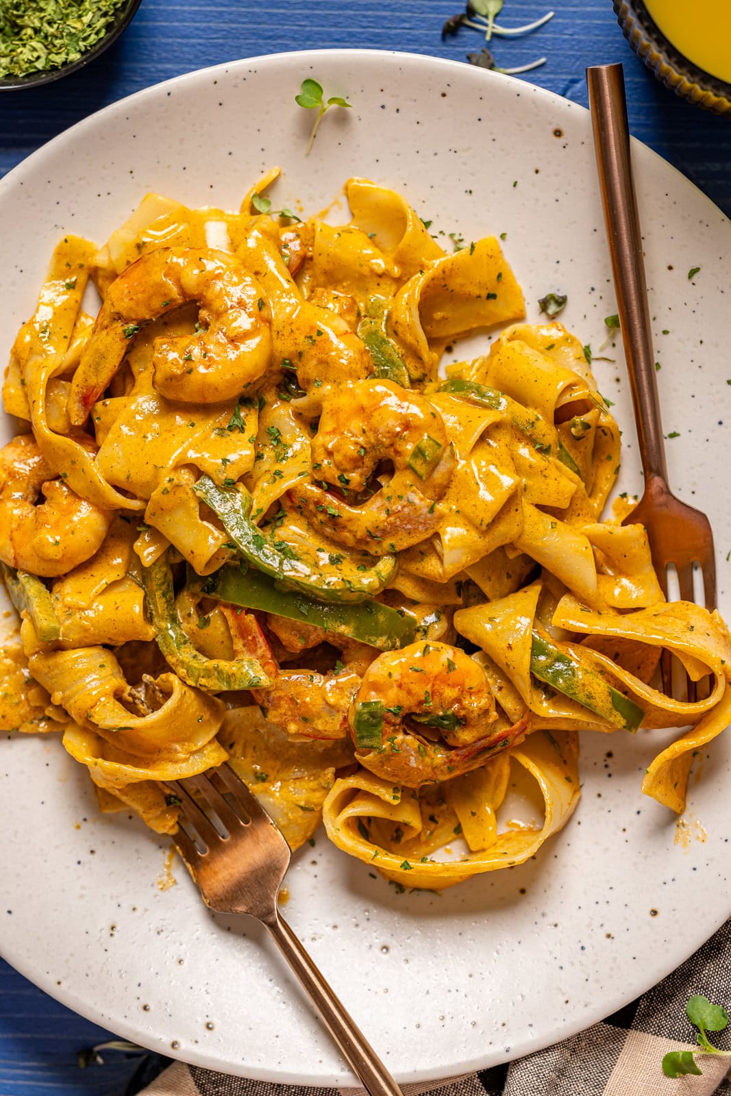 Up close shot of shrimp pasta with two forks.