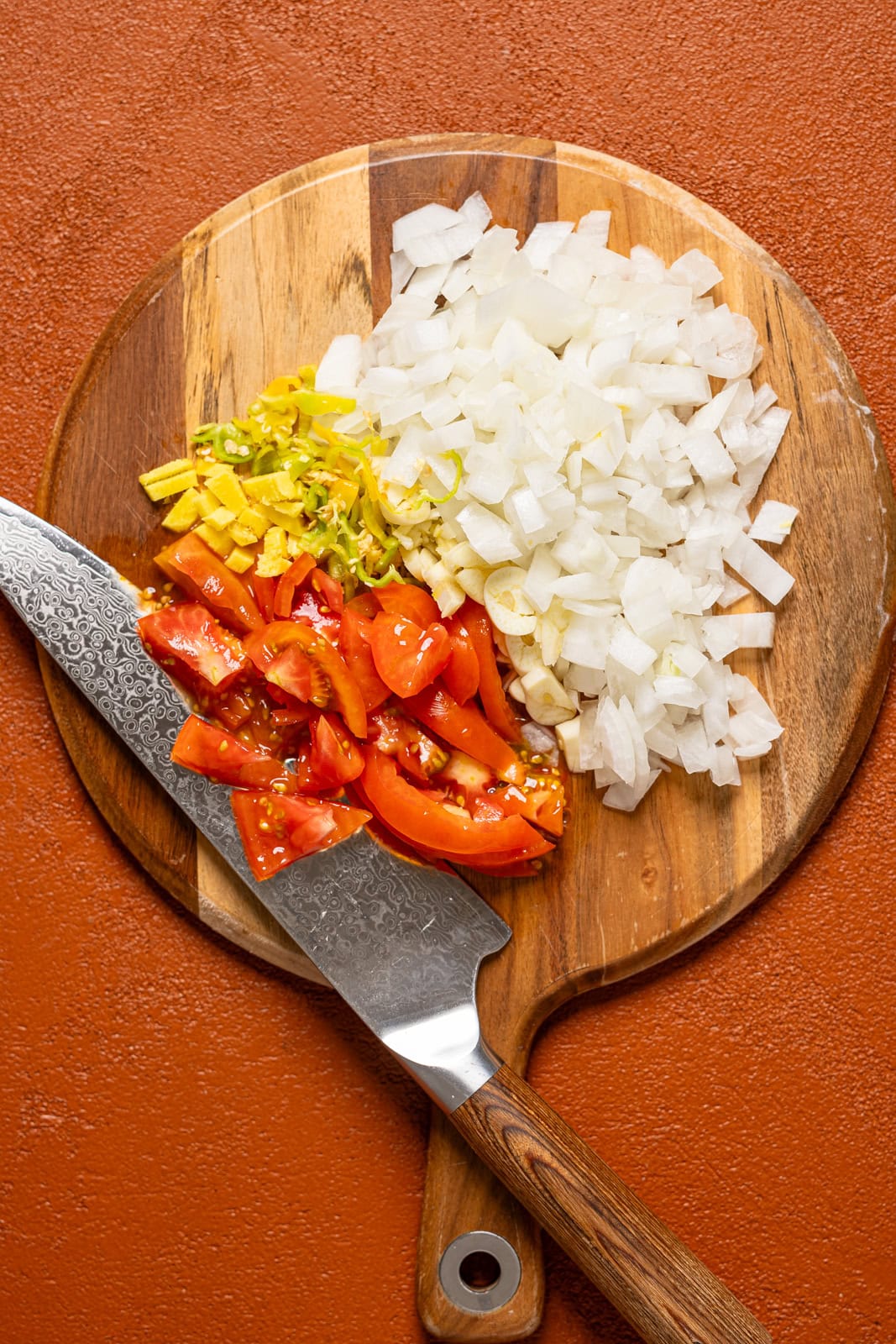 Veggies chopped on cutting board with a knife. 