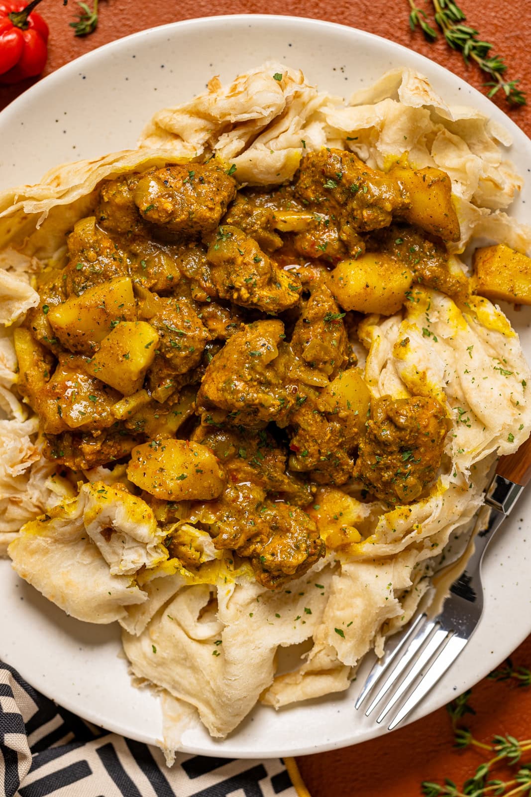 Up close shot of roti on a plate with a fork.
