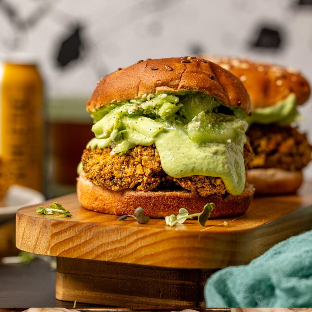 Two crispy chicken sandwiches on a wooden platter.