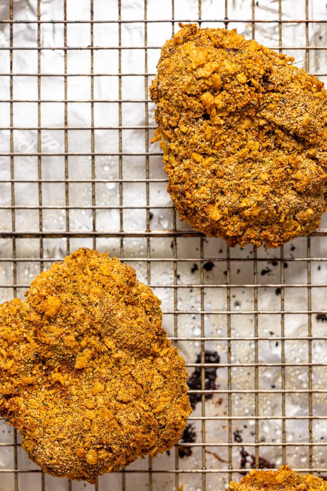 Crispy chicken breasts on a baking sheet with wire rack.