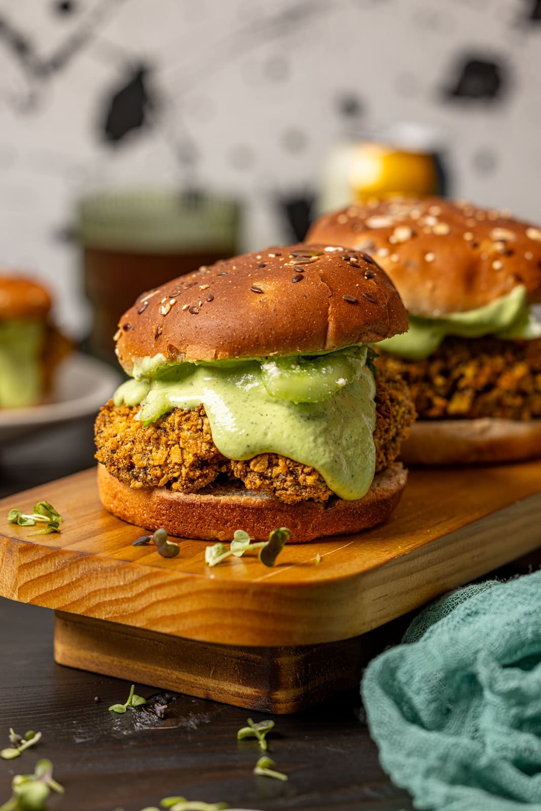 Two crispy chicken sandwiches on a wooden platter.
