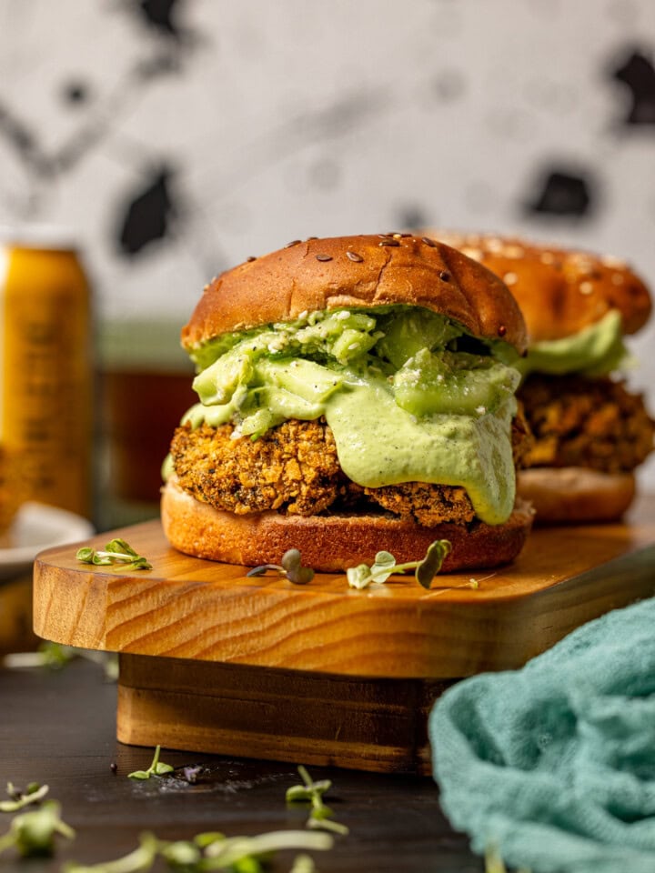 Two crispy chicken sandwiches on a wooden platter.