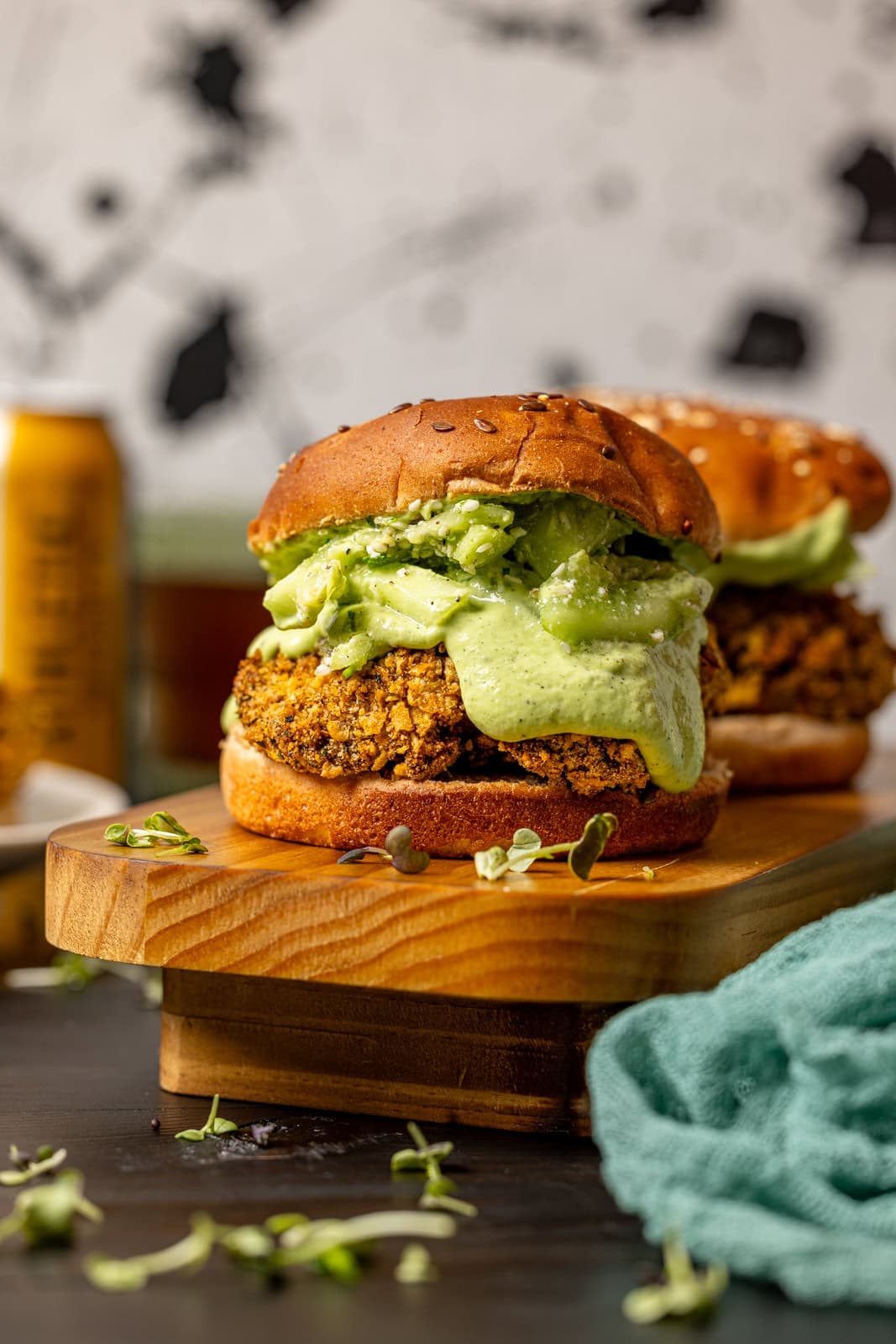 Two crispy chicken sandwiches on a wooden platter.